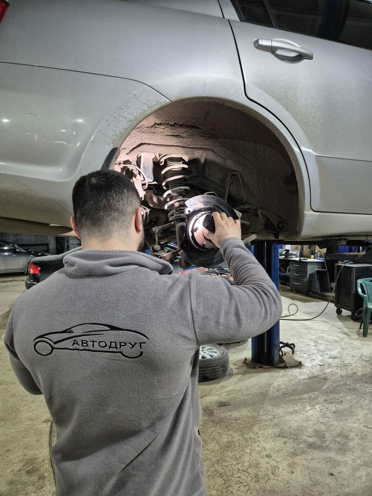 Мастер «АвтоДруга» в фирменной толстовке за работой